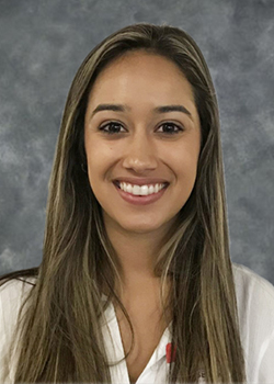 Brown haired woman smiling wearing a white blouse